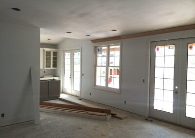 under construction kitchen with white kitchen cabinets, large windows