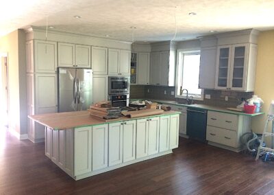 white itchen cabinets, wood flooring, kitchen island with wooden countertop