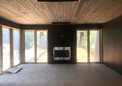 under construction living room ,wood ceiling, large sliding windows, custom fireplace