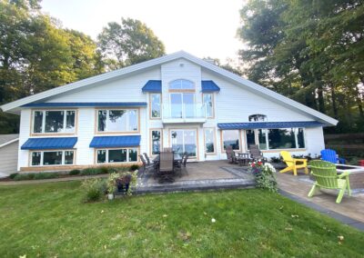white custom home, blue roof, wide frontyard