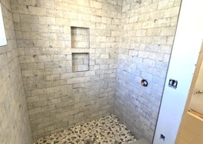 bathroom with brick walls stone shower flooring