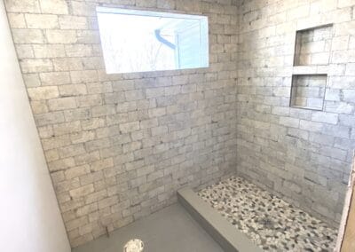 bathroom with brick walls stone shower flooring