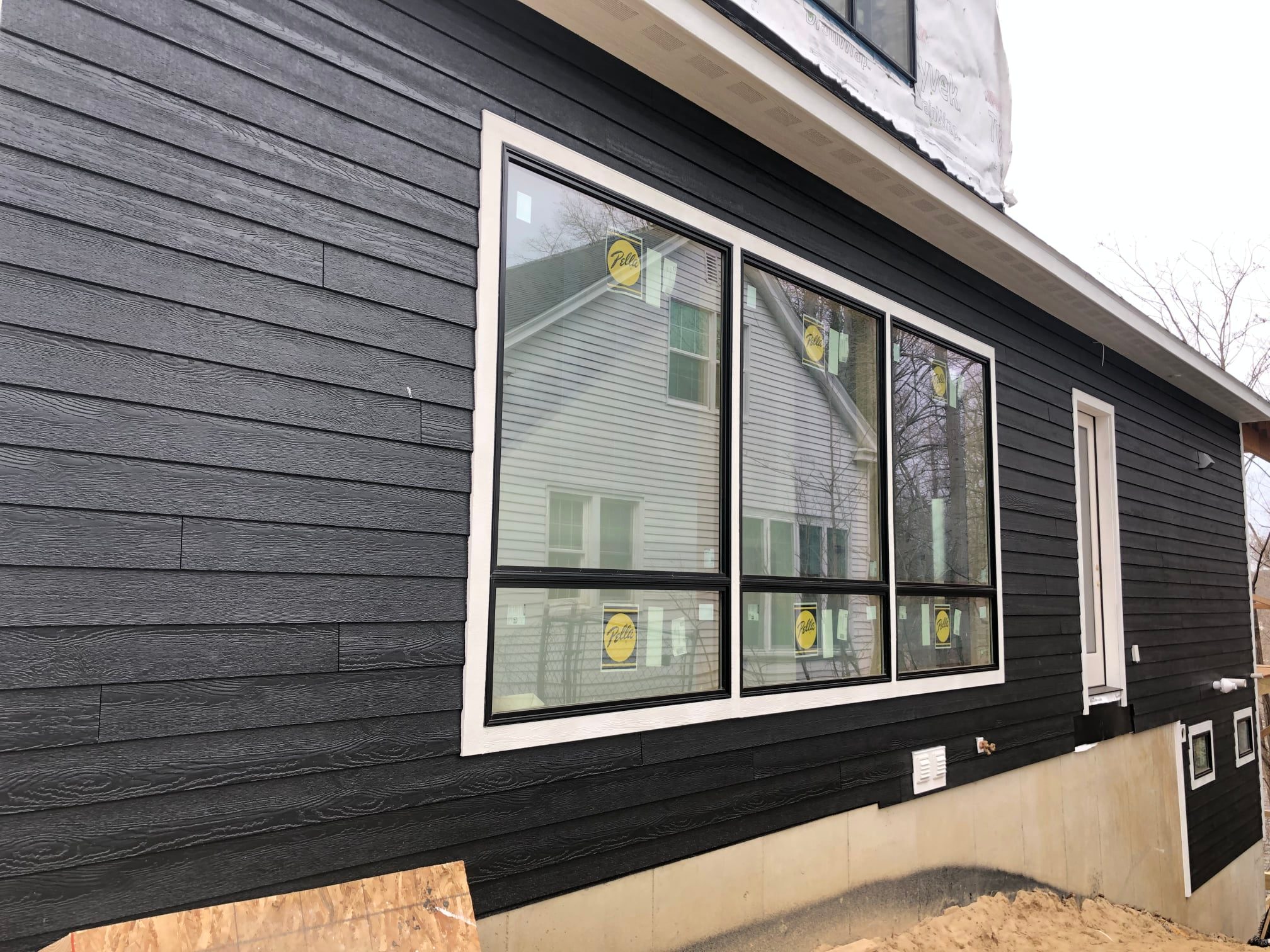 custom home with black wood sidings, large windows